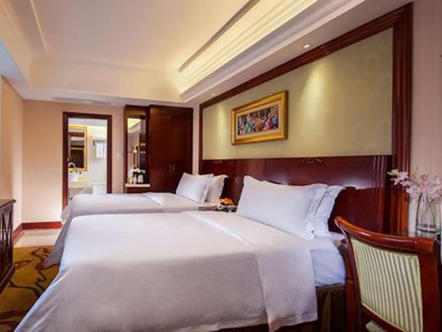 a hotel room with two beds and a table at Vienna Hotel Guangzhou Shiling in Huadu
