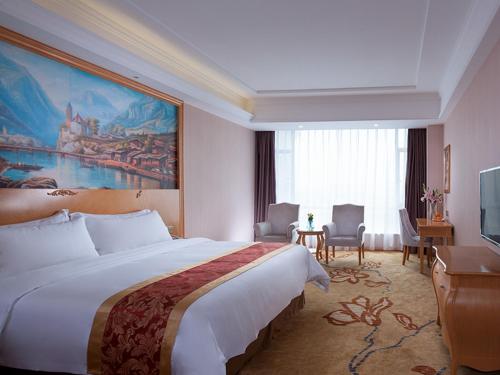 a hotel room with a large bed and a television at Vienna Hotel Dongguan Hou Avenue Jinzuo in Hetian