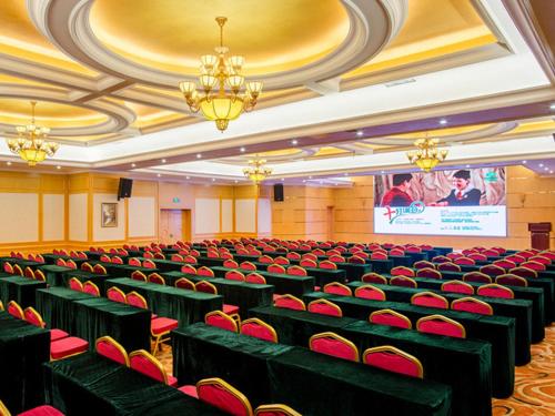 a conference room with red chairs and a screen at Vienna Hotel Changsha Jingwanzi Middle Mulian Road in Changsha