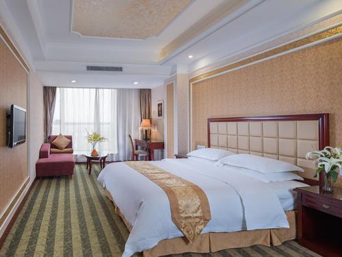 una camera con un grande letto e un soggiorno di Vienna Hotel Songgang Yanchuan Road a Bao'an