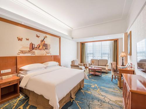 Vienna Hotel Zhengzhou Airport tesisinde bir odada yatak veya yataklar