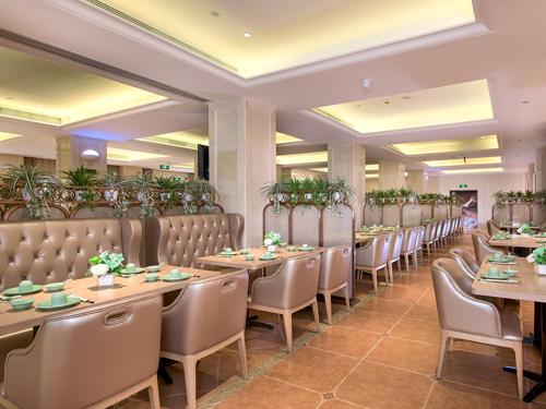 a row of tables and chairs in a restaurant at Vienna International Hotel (Changfeng Park Shop, Jinshajiang Road, Shanghai) in Shanghai
