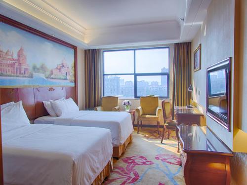 a hotel room with two beds and a large window at Vienna Hotel Guangxi Liuzhou Luzhai in Luzhai