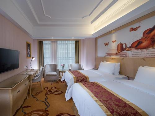 Cette chambre comprend 2 lits et une télévision à écran plat. dans l'établissement Vienna International Hotel Dongguan Shilonghuixing Business Central, à Dongguan