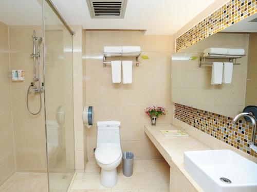 La salle de bains est pourvue de toilettes, d'une douche et d'un lavabo. dans l'établissement Vienna Hotel Shenzhen Guanlan Renming Road Heping, à Tiantangwei