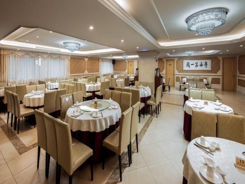 - un restaurant avec des tables et des chaises dans une salle dans l'établissement Vienna International Hotel Guangzhou Airport Xinshi, à Canton