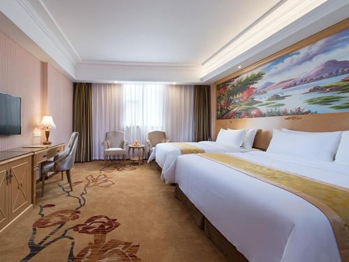 Cette chambre comprend deux lits et une télévision. dans l'établissement Vienna 3 Best Hotel Guangzhou Panyu Jinjiang Ave, à Canton