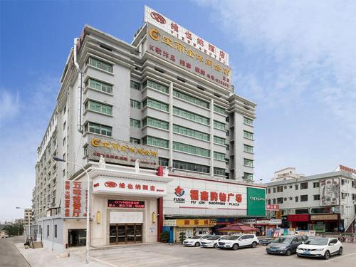 un gran edificio con coches estacionados frente a él en Vienna Hotel (Huizhou Daya Bay Xinyi Store), en Huizhou