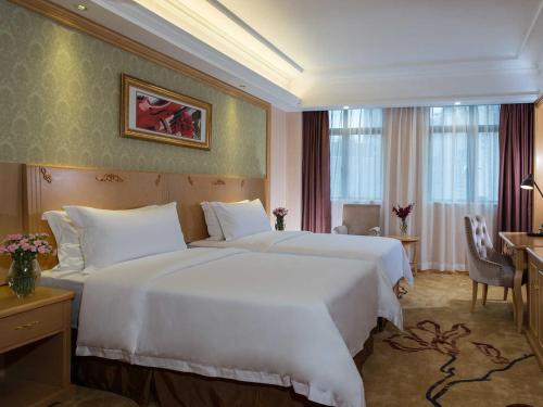 een hotelkamer met twee grote witte bedden bij Vienna Hotel Shenzhen East Railway Station in Shenzhen