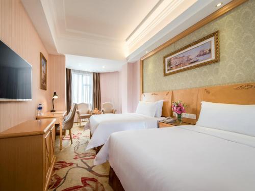 a hotel room with two beds and a desk at Vienna 3 Best Hotel Guangzhou Guangzhou Tower in Guangzhou