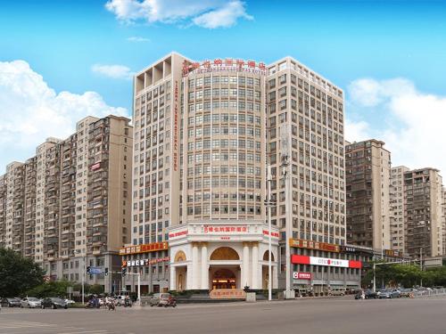 um grande edifício em frente a um parque de estacionamento em Vienna International Hotel Changsha Yinshan Road em Changsha