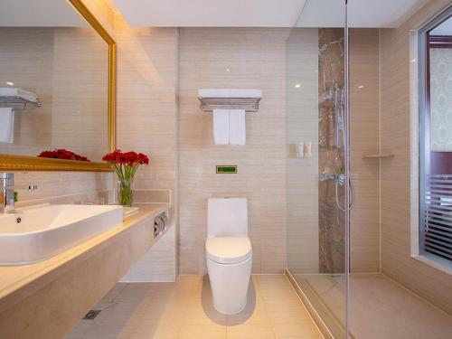 a bathroom with a toilet and a sink and a shower at Vienna Hotel Guangzhou Shiling in Huadu