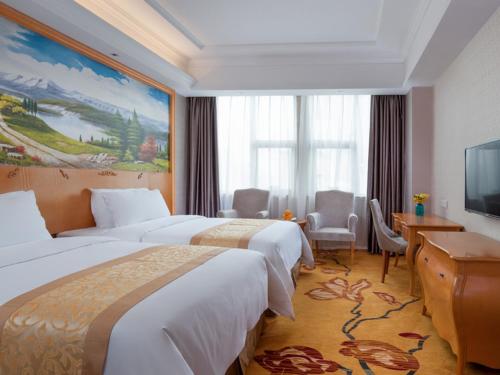 een hotelkamer met 2 bedden en een flatscreen-tv bij Vienna Hotel Guangzhou Beijing Road in Guangzhou