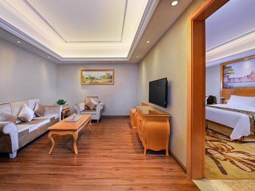 a hotel room with a bed and a couch at Vienna International Hotel (Shen Zhen Buji Dafen shop) in Shenzhen
