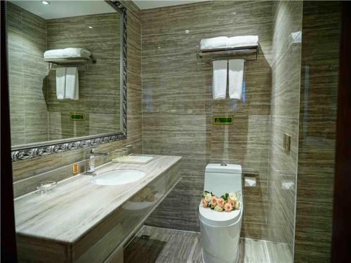 bagno con lavandino e servizi igienici con cesto di frutta di Vienna Hotel Guangxi Liuzhou Luzhai a Luzhai