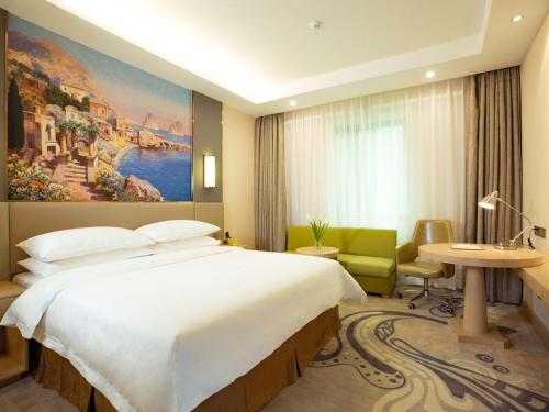 a hotel room with a large bed and a desk and chair at Vienna International Hotel Xian High Technology Road in Xi'an