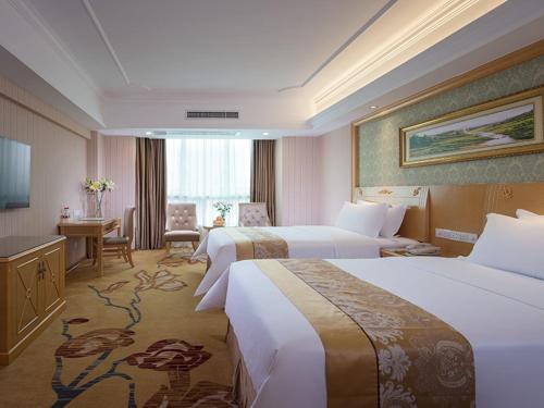 a hotel room with two beds and a desk at Vienna Hotel Nanning Qingxiu Mountain in Nanning