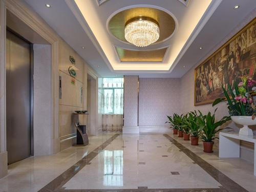 a lobby with a ceiling with a chandelier and plants at Vienna Hotel Baoan Liutang in Xin'an