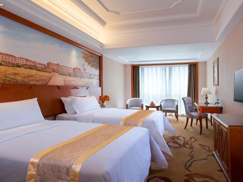 a hotel room with two beds and a television at Vienna International Hotel Foshan Qiandeng Lake in Foshan