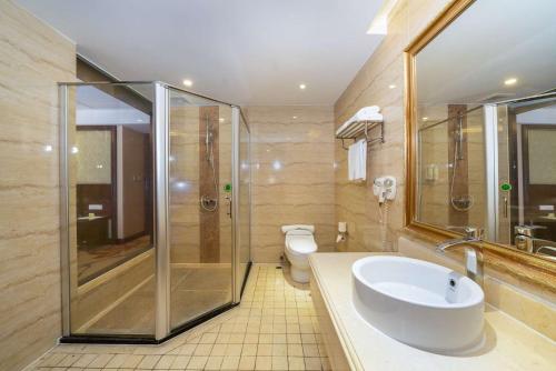 a bathroom with a sink and a shower and a toilet at Vienna Hotel Dongguan Houjie Exhibition Center in Dongguan