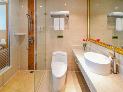 a bathroom with a toilet and a sink and a shower at Vienna Hotel Kunshan North Qingyang Road in Kunshan