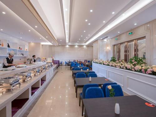 Xinyi的住宿－維也納國際酒店茂名信宜新尚路店，一间配备有桌子和蓝色椅子的用餐室,
