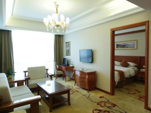 una camera d'albergo con letto e soggiorno di Vienna Classic Hotel Kongtong Avenue a Pingliang