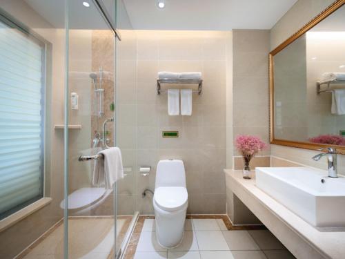 a bathroom with a toilet and a sink and a shower at Vienna Hotel Nanjing Baijiahu Ximenzi in Nanjing