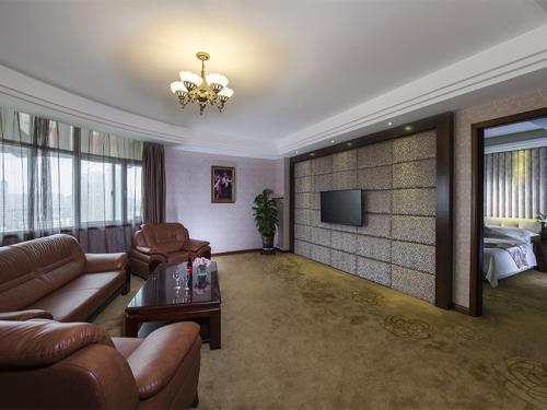 a living room with a couch and a television at Vienna Hotel Nanning Jiangnan Wanda in Nanning
