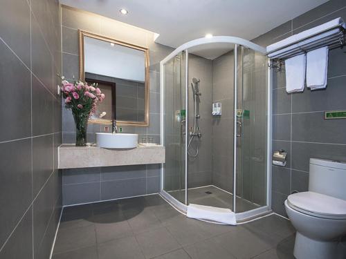 a bathroom with a shower and a toilet and a sink at Vienna Hotel Guangzhou Shaheding Metro Station in Guangzhou