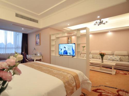 a hotel room with a bed and a flat screen tv at Vienna Hotel Guangxi Guilin in Guilin