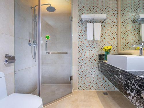 La salle de bains est pourvue d'une douche, de toilettes et d'un lavabo. dans l'établissement Vienna Hotel Shiqiao Metro Station, à Canton