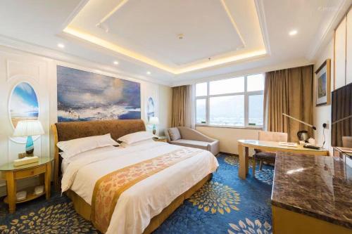 西寧市にあるVienna International Hotel Qinghai Xining Tianjun Bridgeの大きなベッドとデスクが備わるホテルルームです。