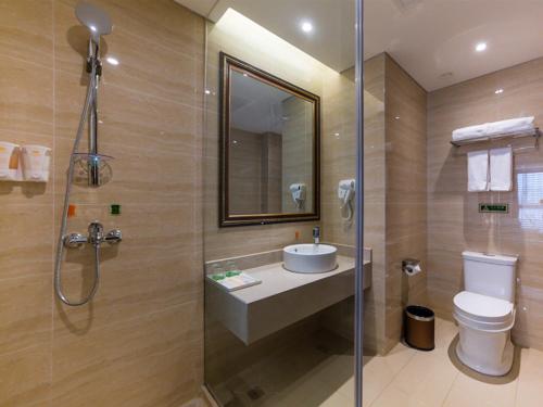 a bathroom with a sink and a toilet and a shower at Vienna Hotel Songjiang Wanda Guangfulin Road in Songjiang