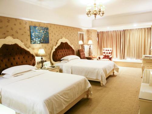 una habitación de hotel con 2 camas y una silla en Vienna Hotel Yongzhou Zhiyuan New Bund, en Yongzhou