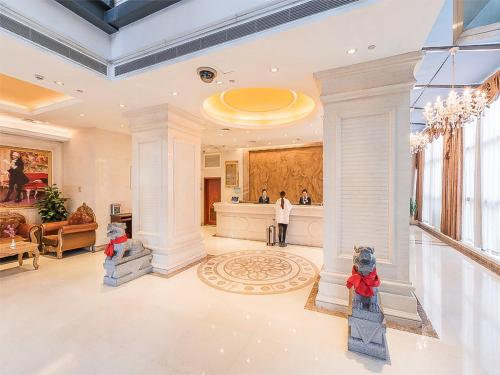 una gran sala de estar con una persona de pie en el vestíbulo en Vienna Hotel Shanghai Baoshan Wusong, en Shanghái