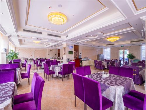 um salão de banquetes com mesas roxas e cadeiras roxas em Vienna Hotel Guilin ShiFu Branch em Lingui