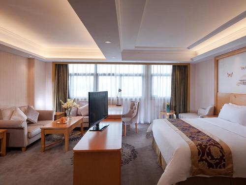 um quarto de hotel com uma cama e uma sala de estar em Vienna Hotel Dongguan Tangxia Garden Street em Tangxia