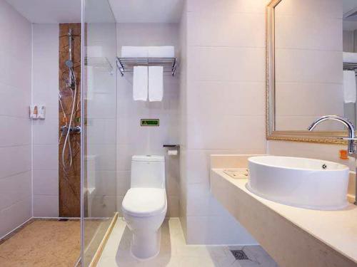 Baño blanco con aseo y lavamanos en Vienna 3 Best Hotel Meizhou Mei County People Square, en Meizhou