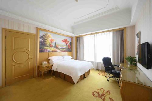 a hotel room with a bed and a television at Vienna International Hotel Shanghai Malu Station in Jiading