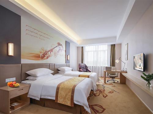 a hotel room with two beds and a desk at Vienna Hotel(Nanjin Fuzimiao Muxuyuan Subway Station) in Nanjing