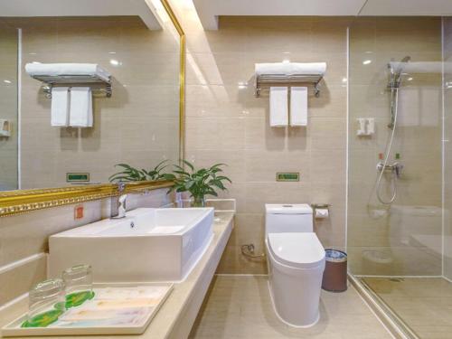 ein Badezimmer mit Waschbecken, Toilette und Dusche in der Unterkunft Vienna Hotel Guilin AIrport Road Rongshan in Guilin