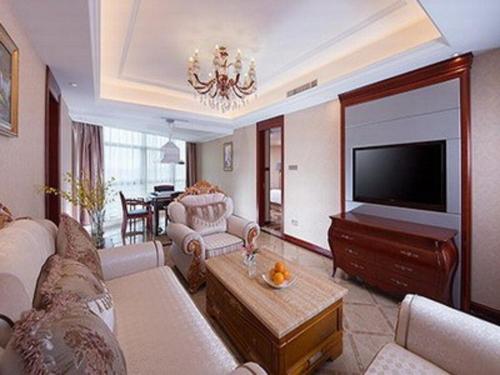 sala de estar con sofá y TV de pantalla plana en Vienna International Hotel Dongguan Chang'an North Station, en Dongguan