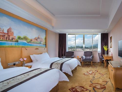 Una habitación de hotel con dos camas y un cuadro en la pared. en Vienna Hotel(Yangchun International Shop ), en Yangchun