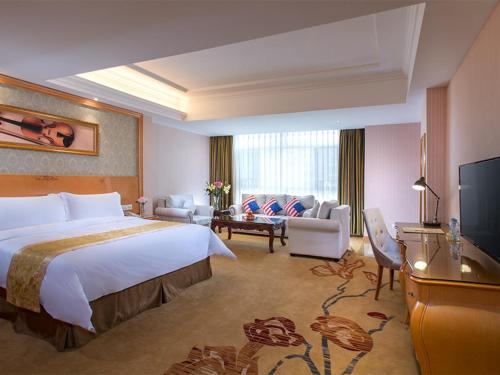 a hotel room with a large bed and a living room at Vienna Hotel Guangdong Heyuan Lianping in Lianping