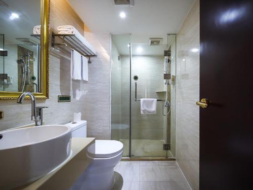 y baño con lavabo, aseo y ducha. en Vienna Hotel Hengyang Zhengxiang, en Hengyang