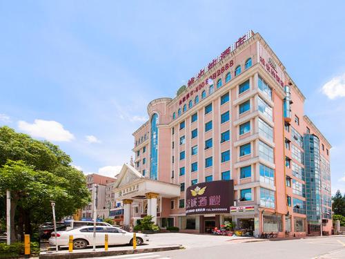 a large building with a car parked in front of it at Vienna Hotel Shenzhen Pingdi in Longgang