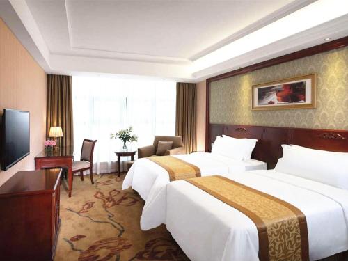 a hotel room with two beds and a television at Vienna Hotel Fujian Xiapu in Xiapu