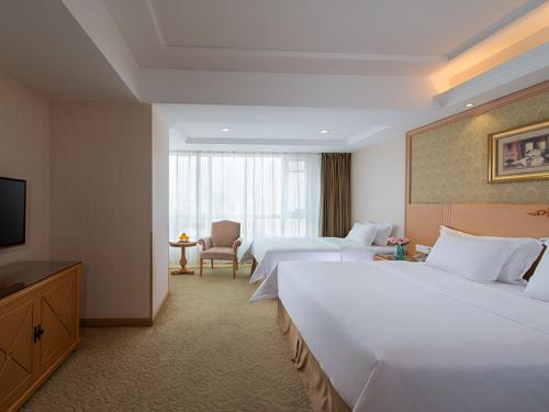 瀋陽市にあるVienna International Hotel Shenyang Railway Stationのベッド2台とテレビが備わるホテルルームです。