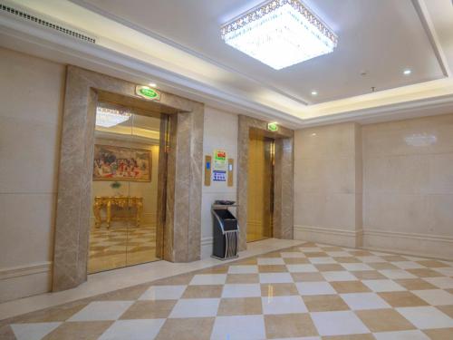 a lobby with a large room with a checkered floor at Vienna Hotel Huizhou Chenjiang Avenue in Huizhou